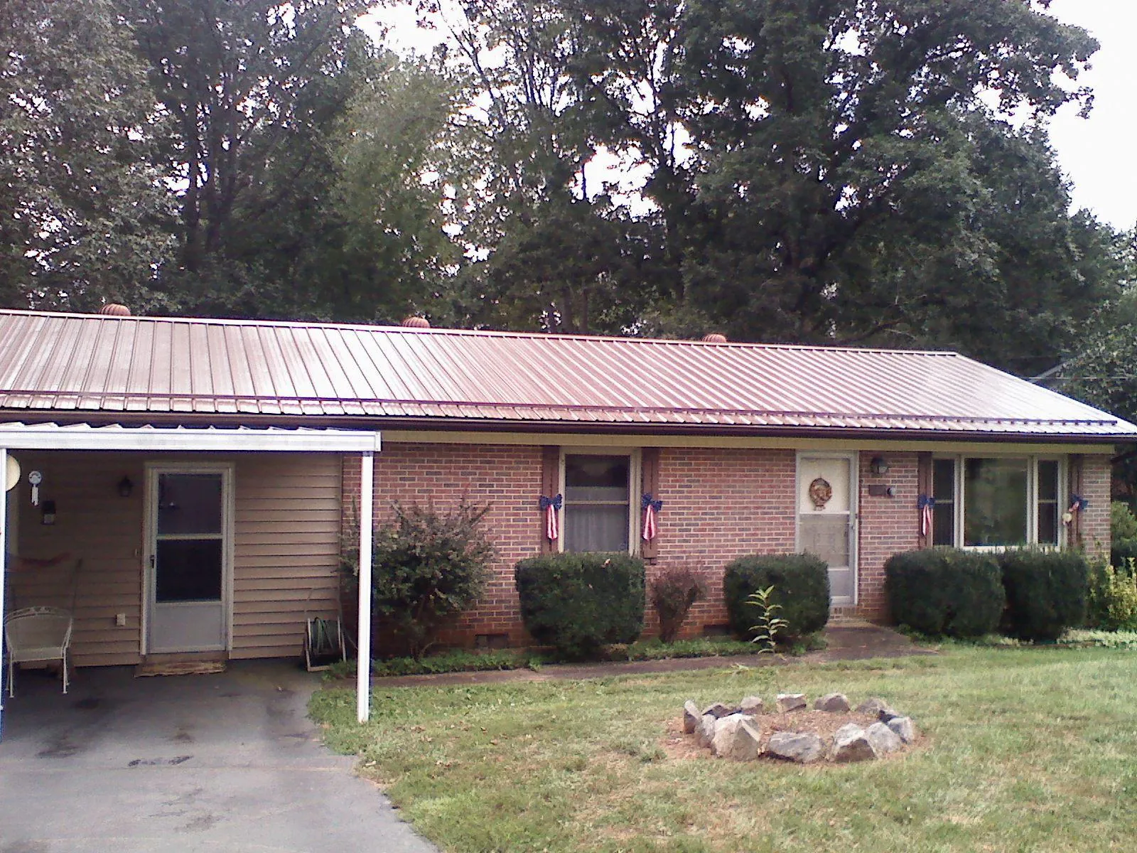Bronze metal roof and carport on a brick ranch home — Roof Repair work by our crew in Wakefield